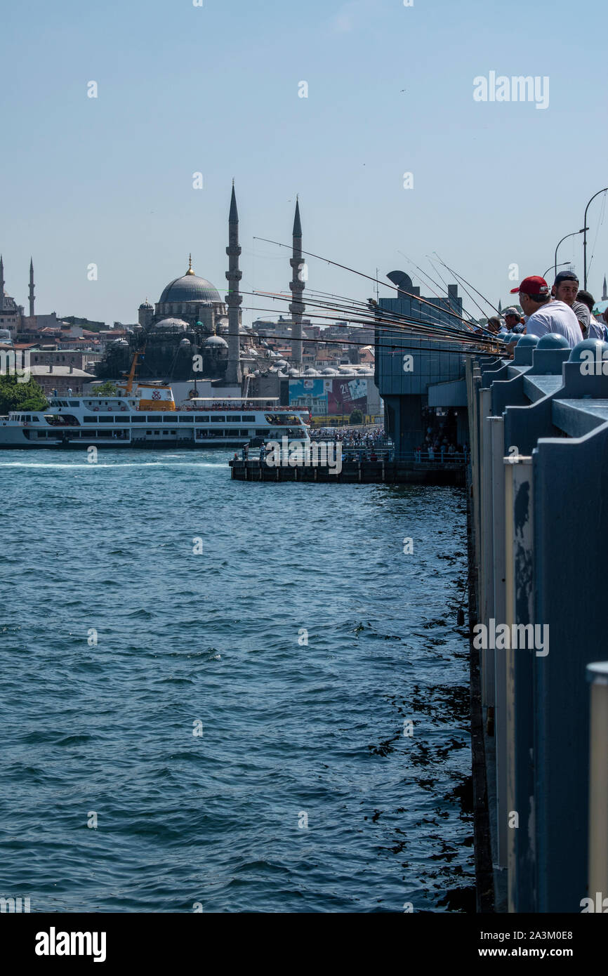 Istanbul: skyline of the city and local fishermen with their fishing rod on the Galata Bridge, the bridge spanning the Golden Horn and the Bosphorus Stock Photo
