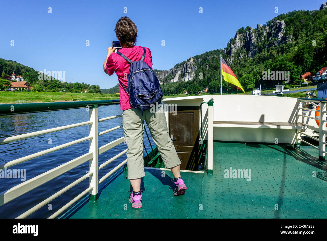 Woman taking photos on a ferry boat board in Elbe river valley Germany Saxon Switzerland holiday Elbe ship Saxon Switzerland Stock Photo