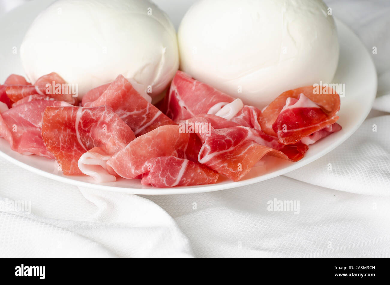 Mozzarella di bufala and prosciutto crudo on white background. Italian  cuisine, space for text Stock Photo - Alamy