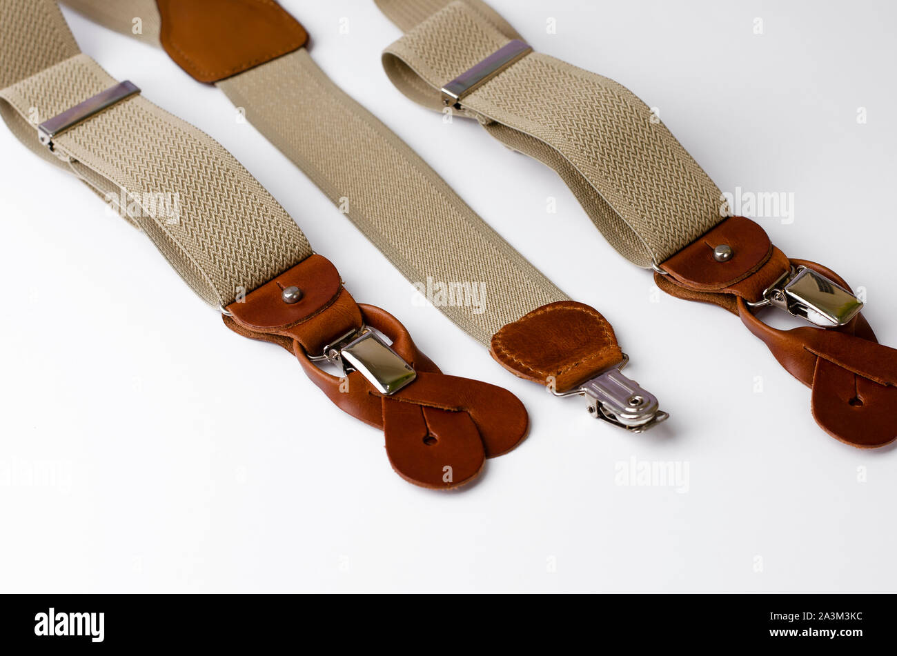 Close-up on Leather details of suspenders on white background. Men's accessories concept Stock Photo