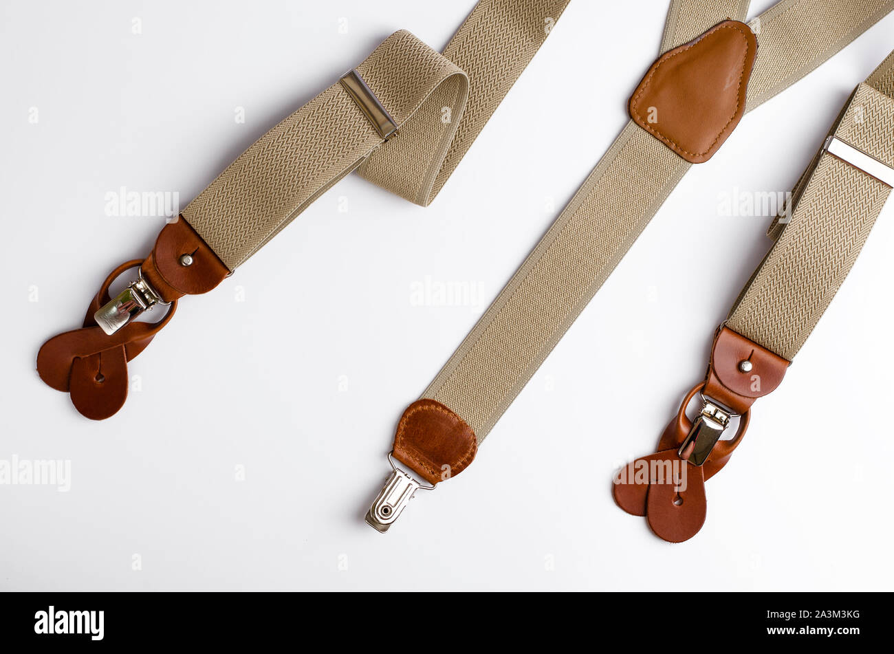 Close-up on Leather details of suspenders on white background. Hipster style concept. Stock Photo
