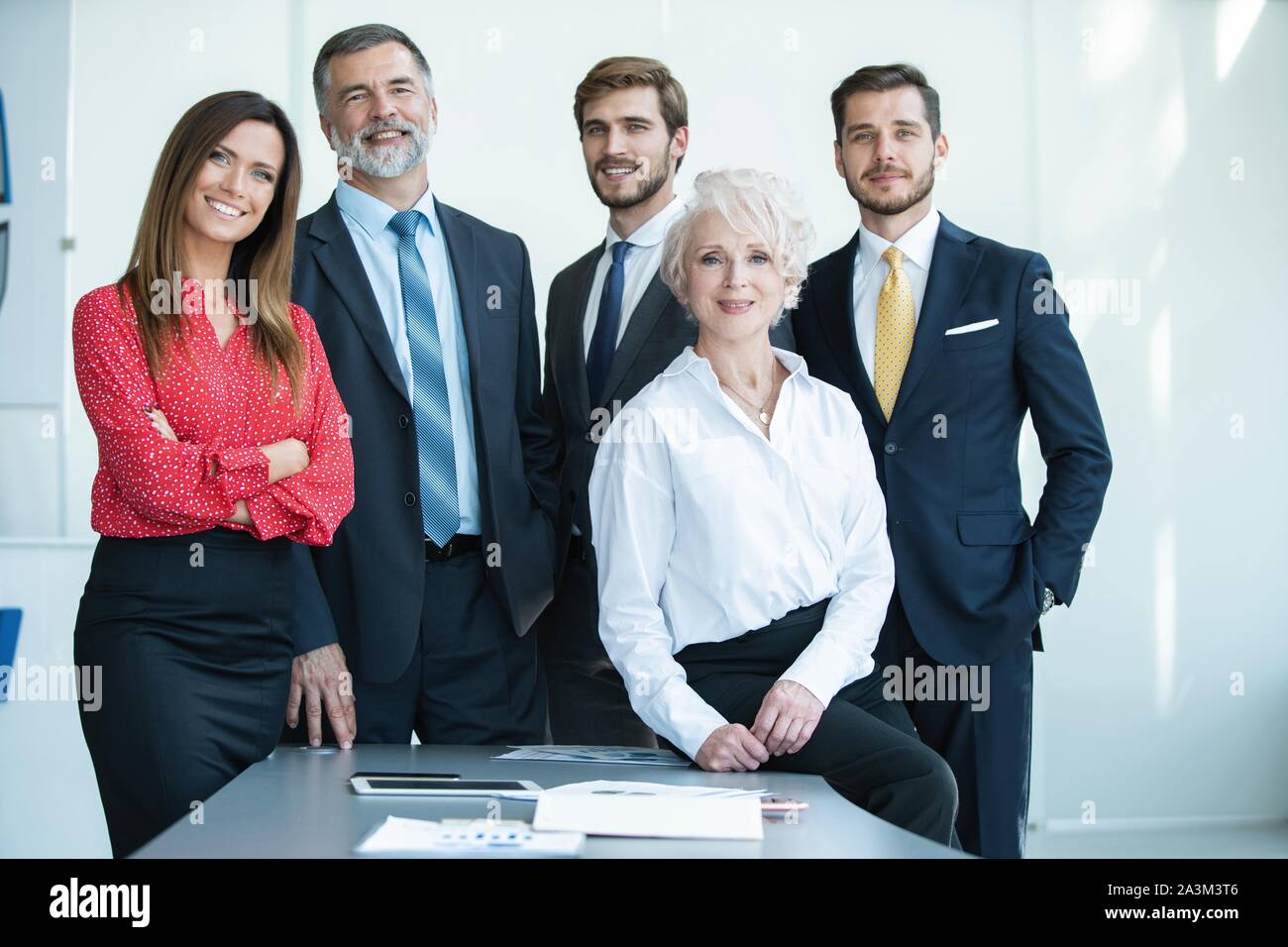 Group of businesspeople standing together in office Stock Photo - Alamy