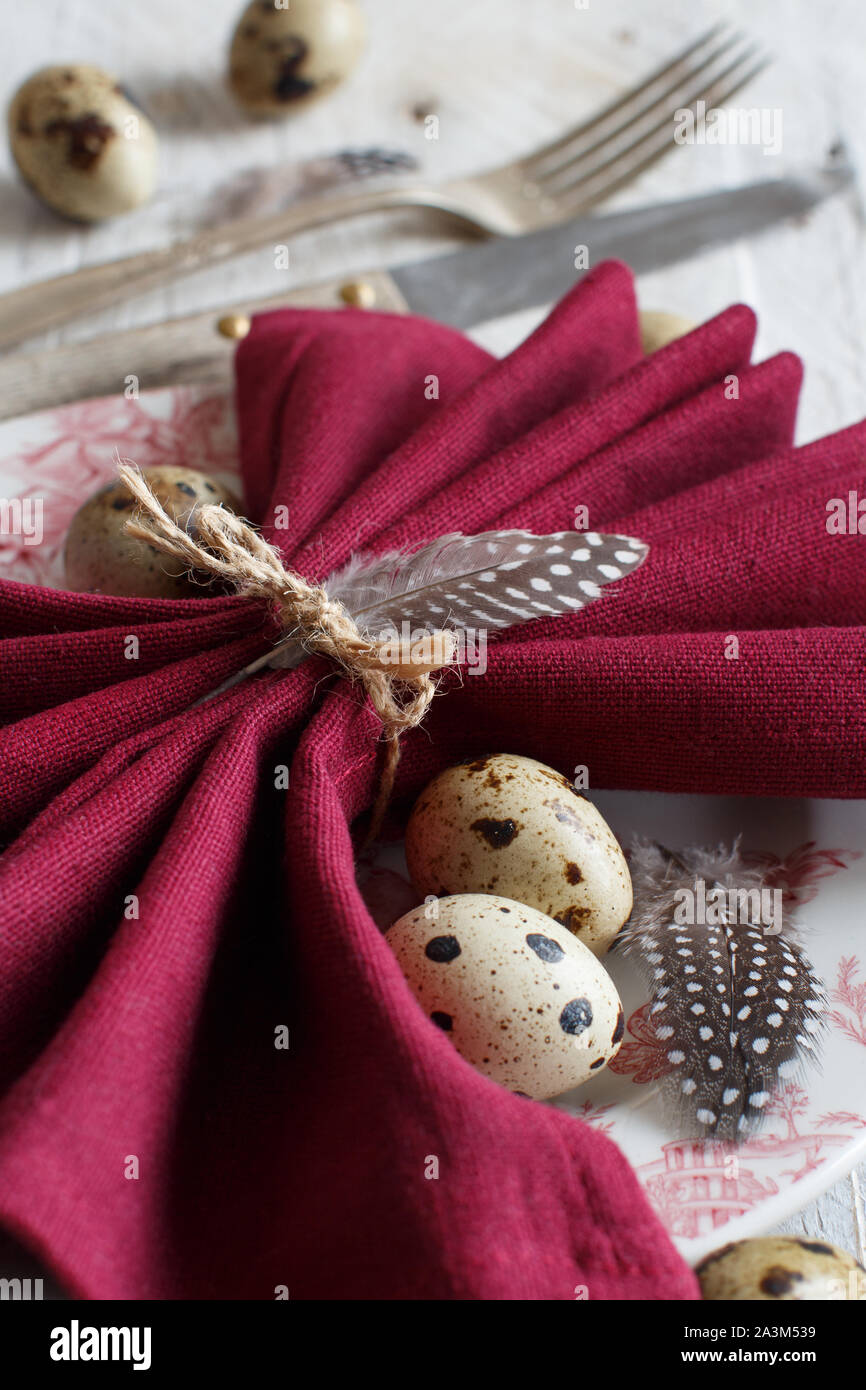 Easter table setting with quail eggs and feathers Stock Photo
