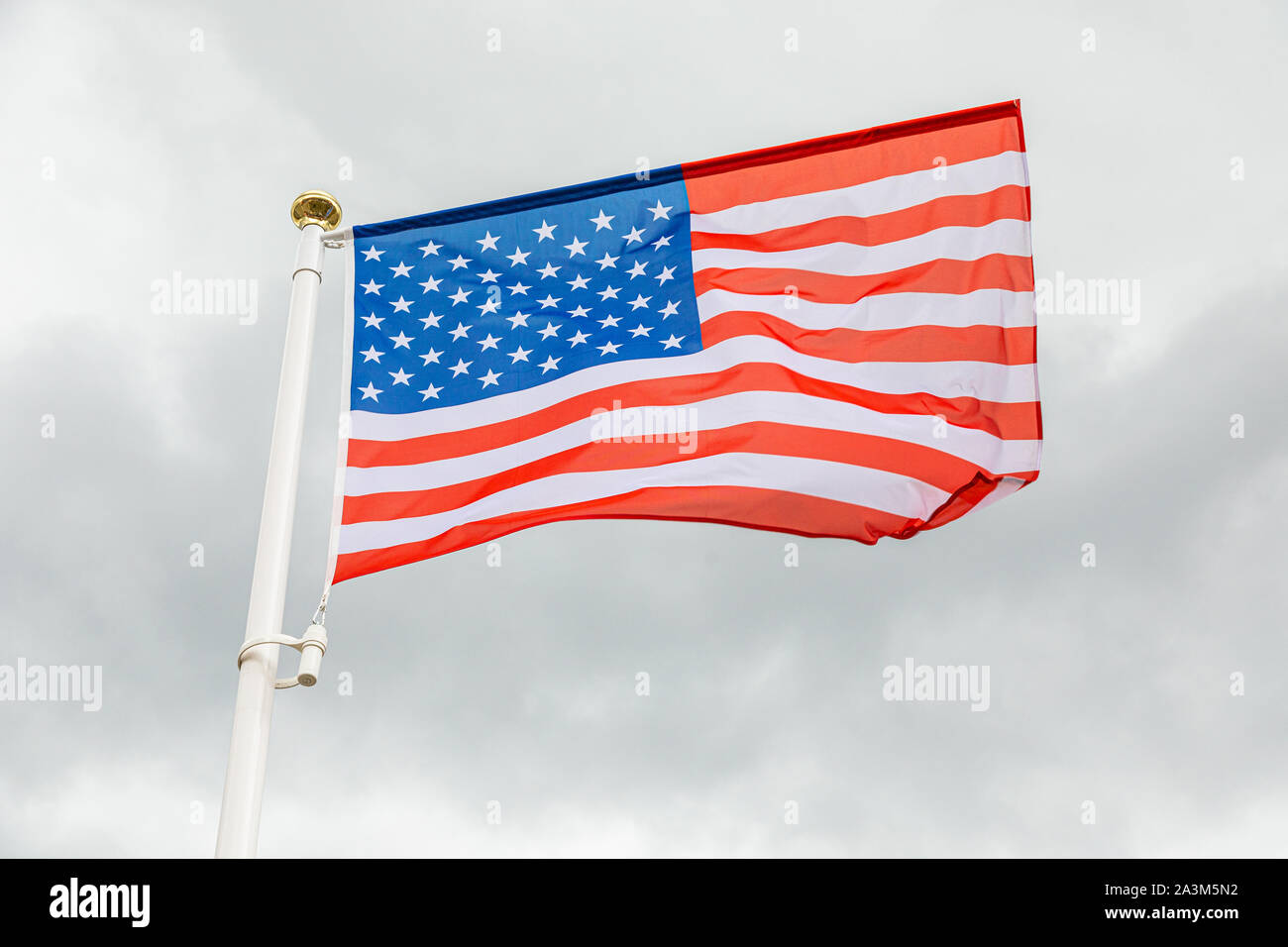 flag of the USA against white cloudy sky Stock Photo - Alamy