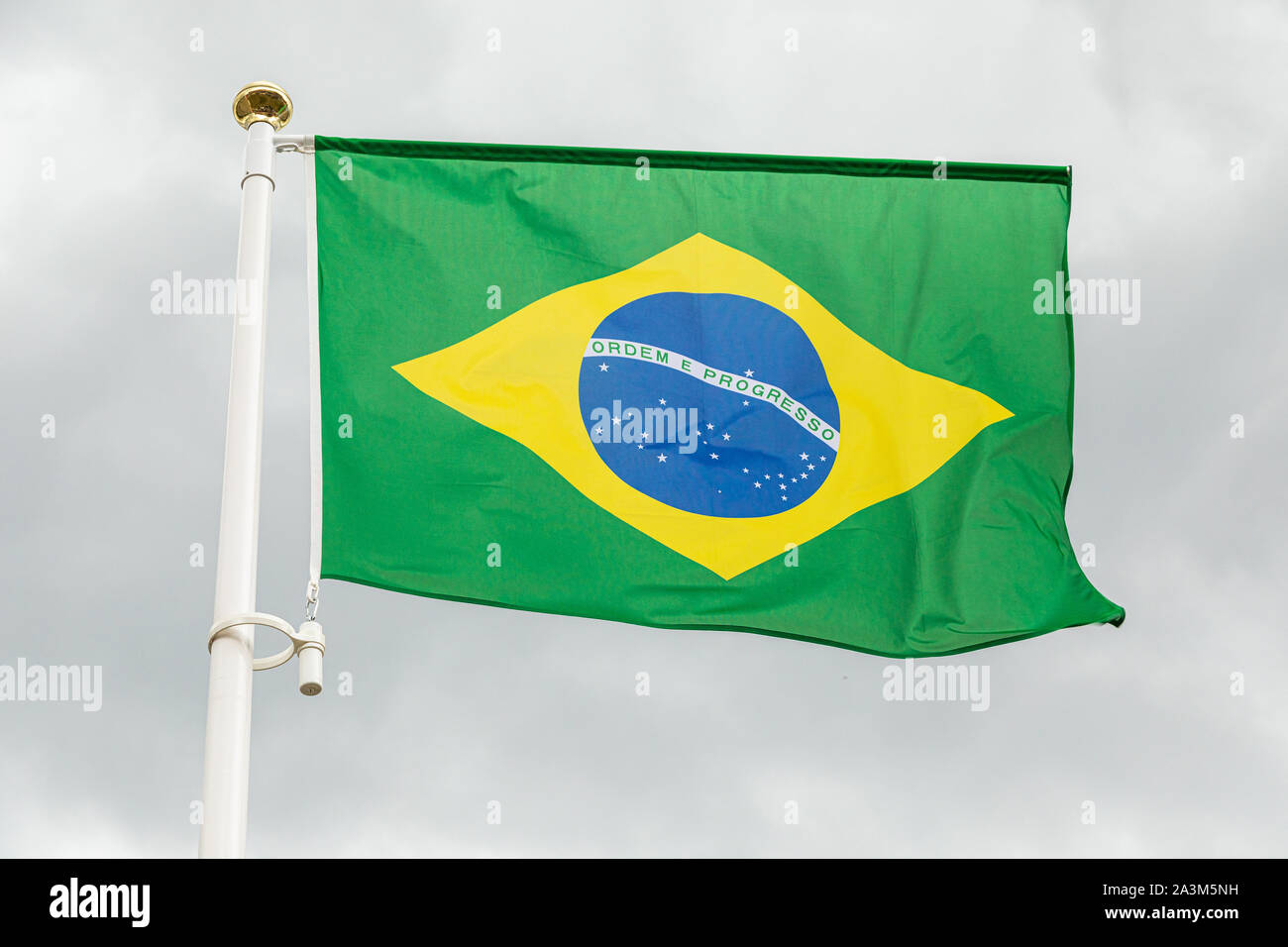 Brazilian flag waving in the wind against white cloudy sky Stock Photo