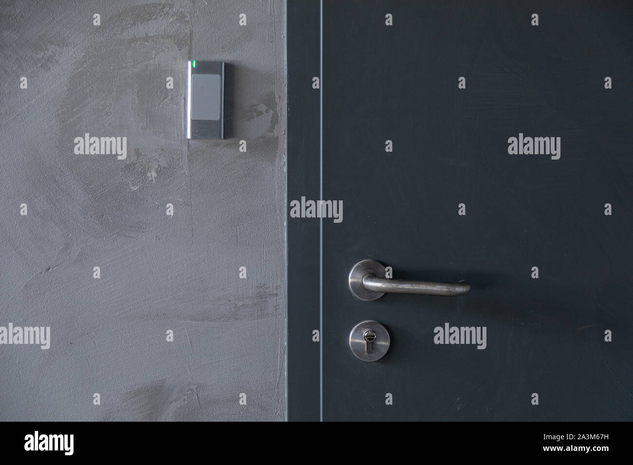 Close-up of metal door with signalization in grey concrete wall Stock Photo