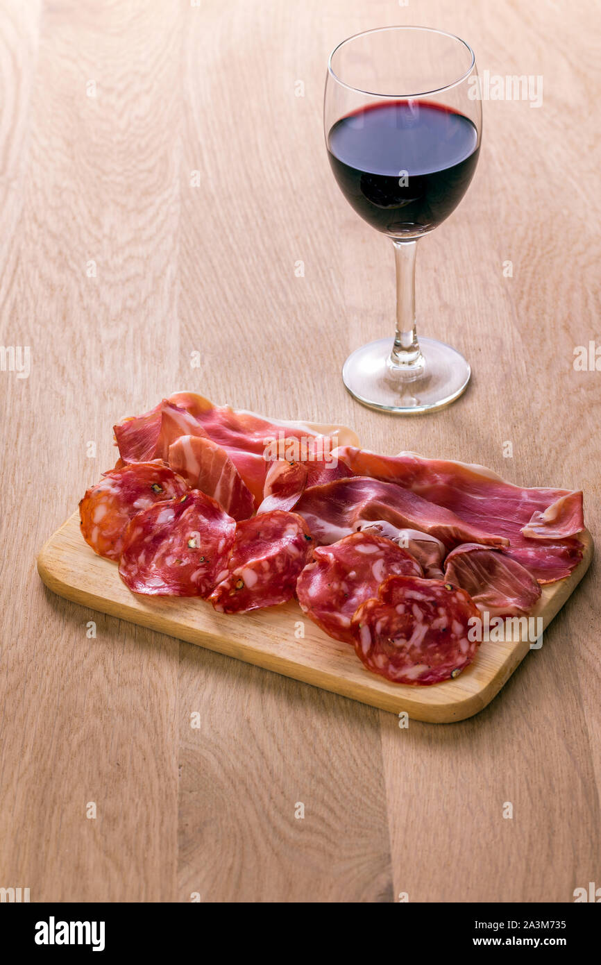 Glass Of Italian Tuscan Red Wine And Cold Cuts On Oak Wood Table