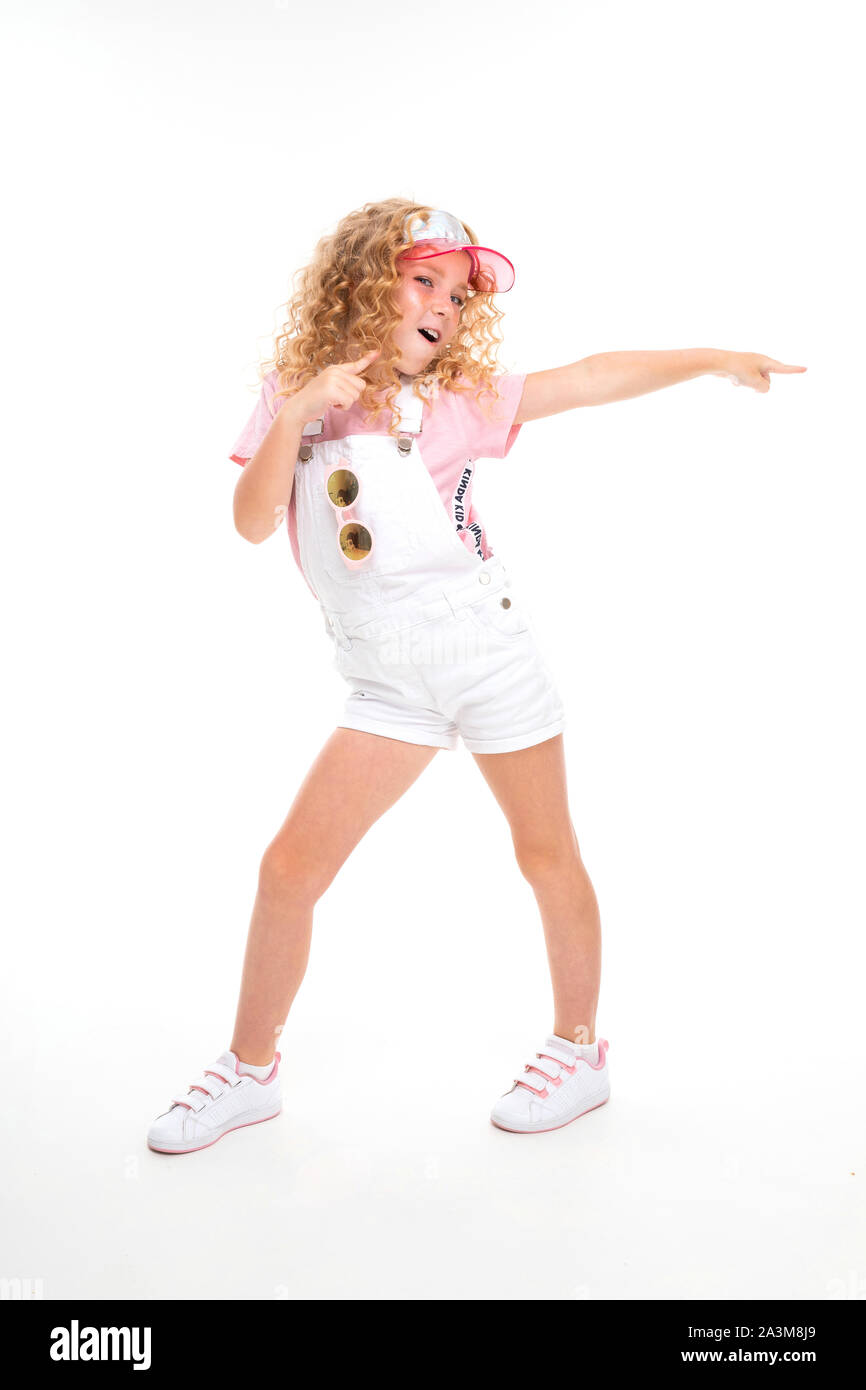A Little Girl With Red Heap Hair In A Shirt White Jumpsuit White