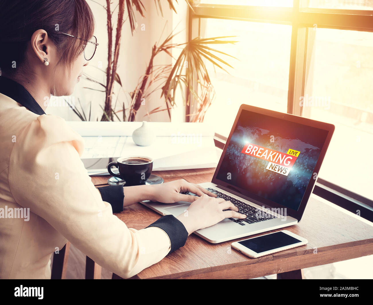 business woman reading fake news or HOAX on internet content via laptop at workplace Stock Photo