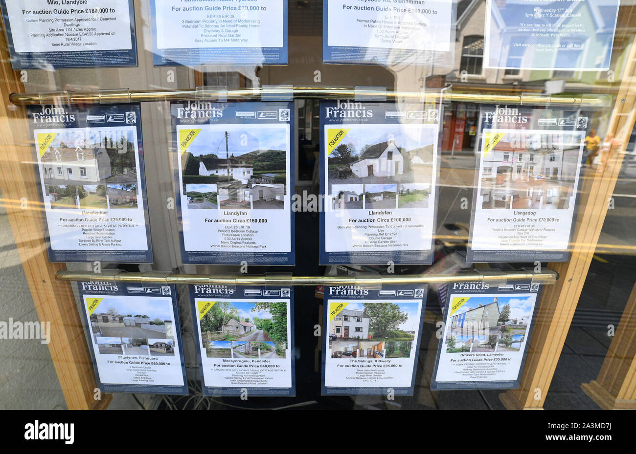 Property for sale cards in a John Francis estate agents window for