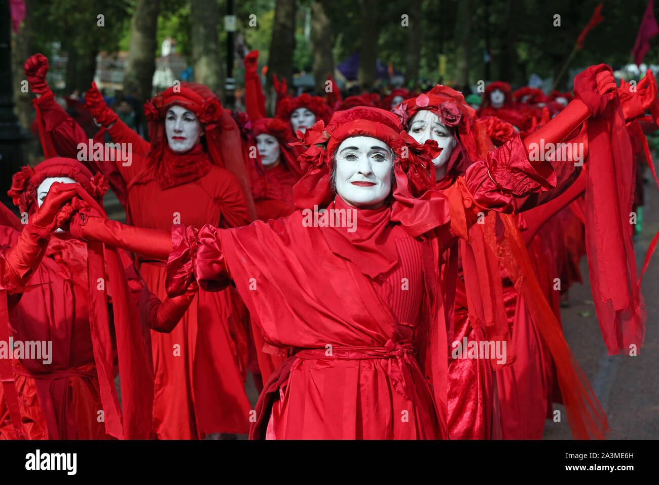 The group known as the Red Rebels in a procession leaving St James's Park, near Birdcage Walk, during the third day of an Extinction Rebellion (XR) protest in Westminster, London. Stock Photo