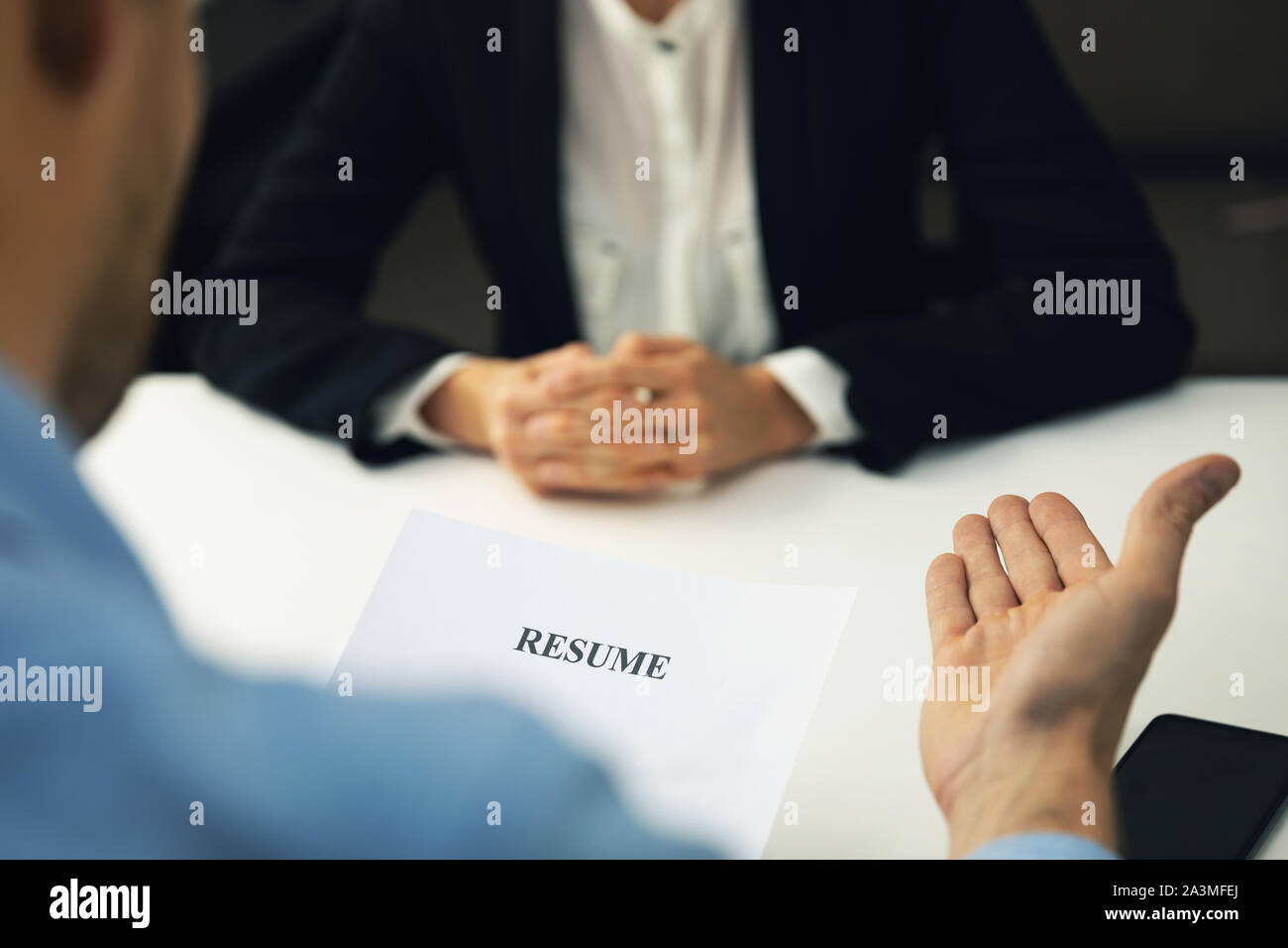 interviewer and candidate discussion in a job interview reviewing resume Stock Photo