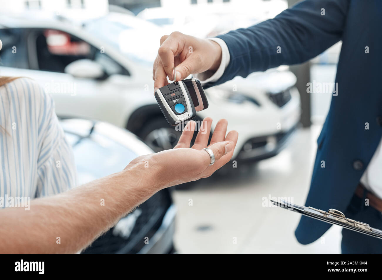 Salesman giving key from rental car to his client Stock Photo - Alamy