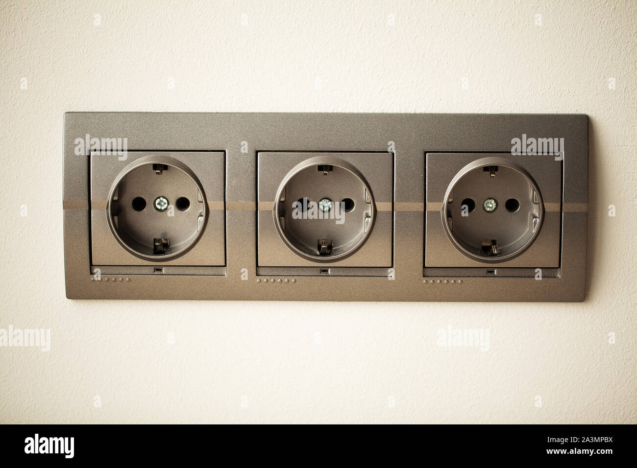 Closeup view of a group of gray european electrical outlets located on