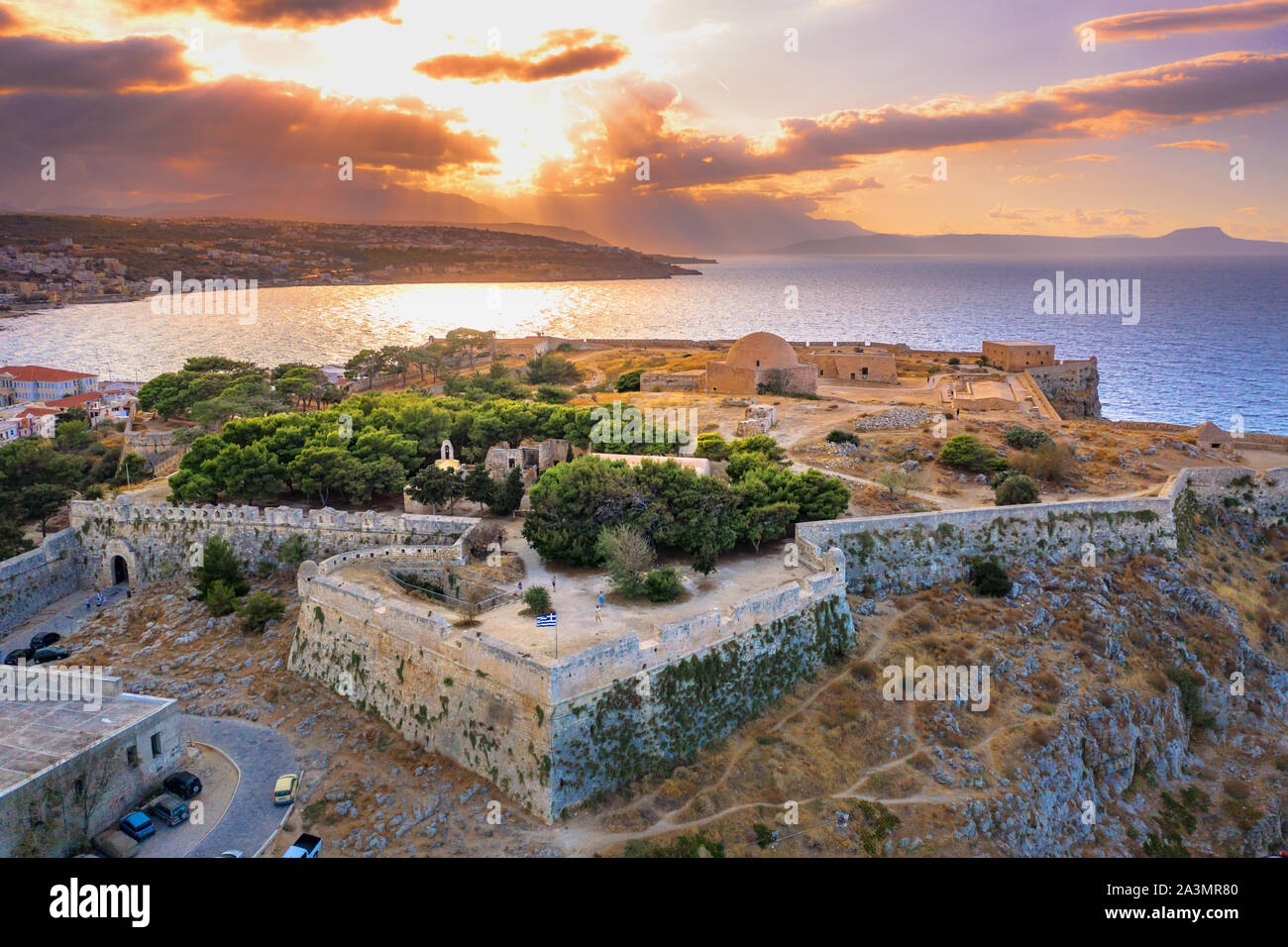 View of the Venetian castle on top of the hill, with perspective road at sunset Rethymno, Crete, Greece Stock Photo
