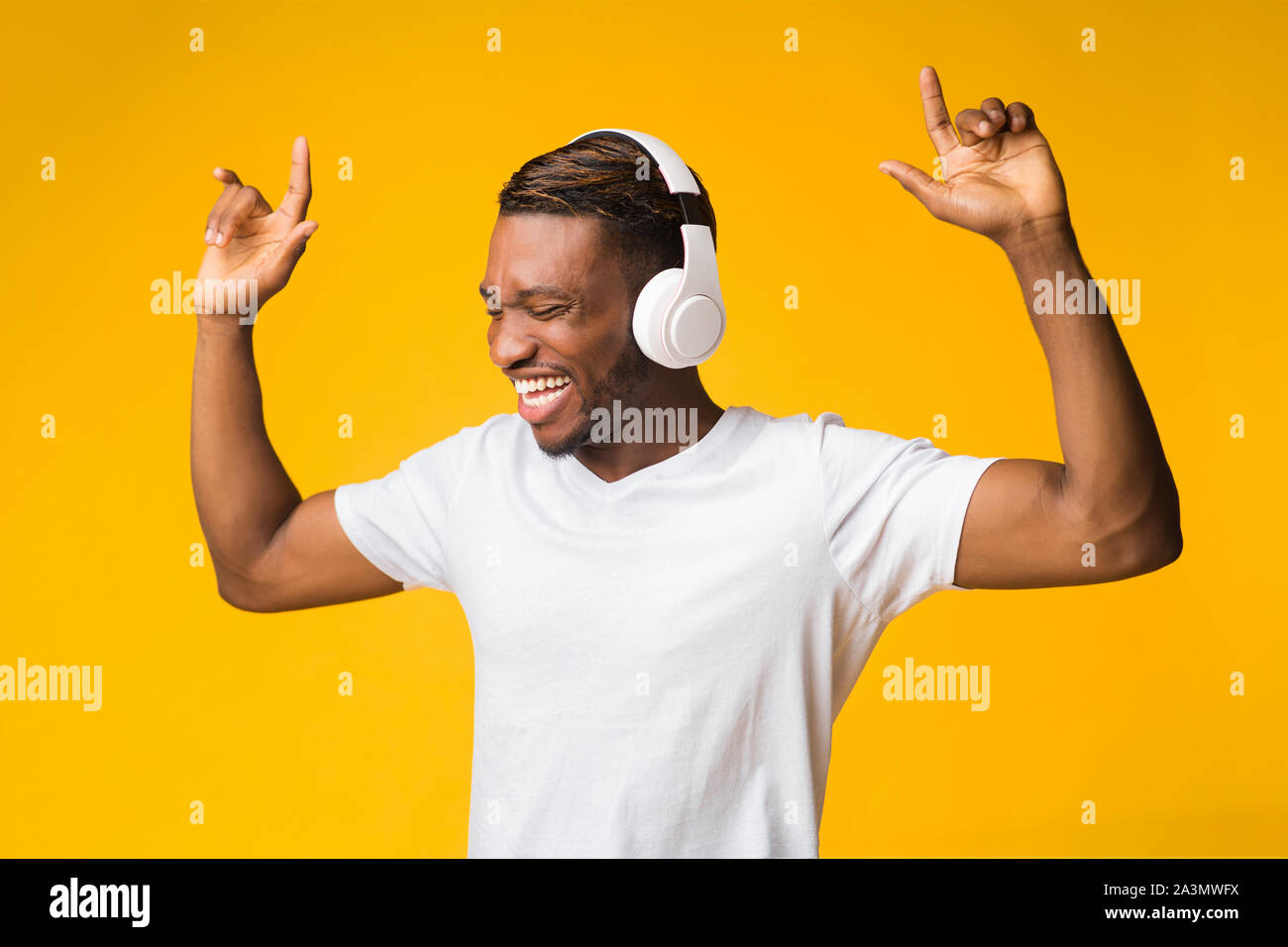 Happy Guy In Headphones Listening To Music Dancing, Studio Shot Stock Photo