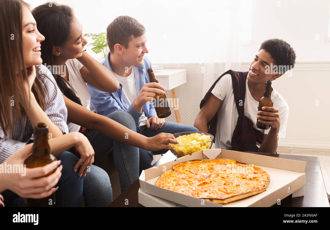 Happy african american friends eating pizza at home Stock Photo by  Prostock-studio