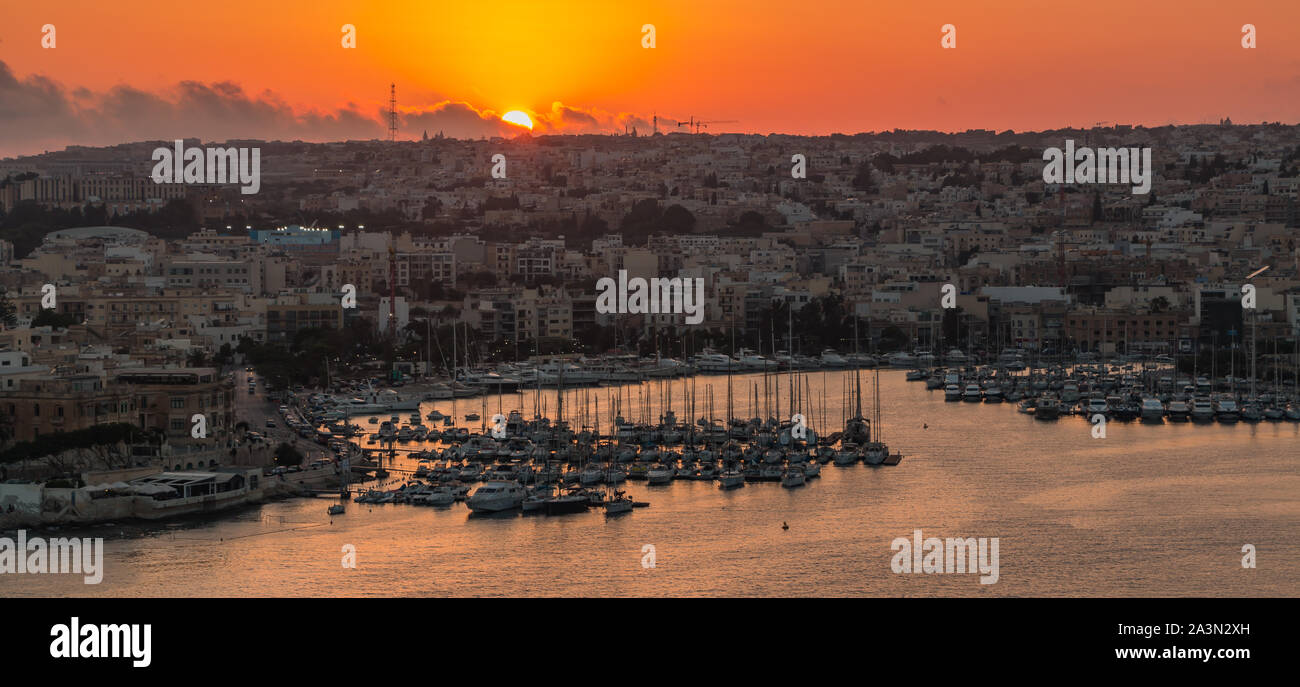 A picture of the sun setting over the coastal areas of Gżira & Ta' Xbiex, in Valletta (Malta). Stock Photo