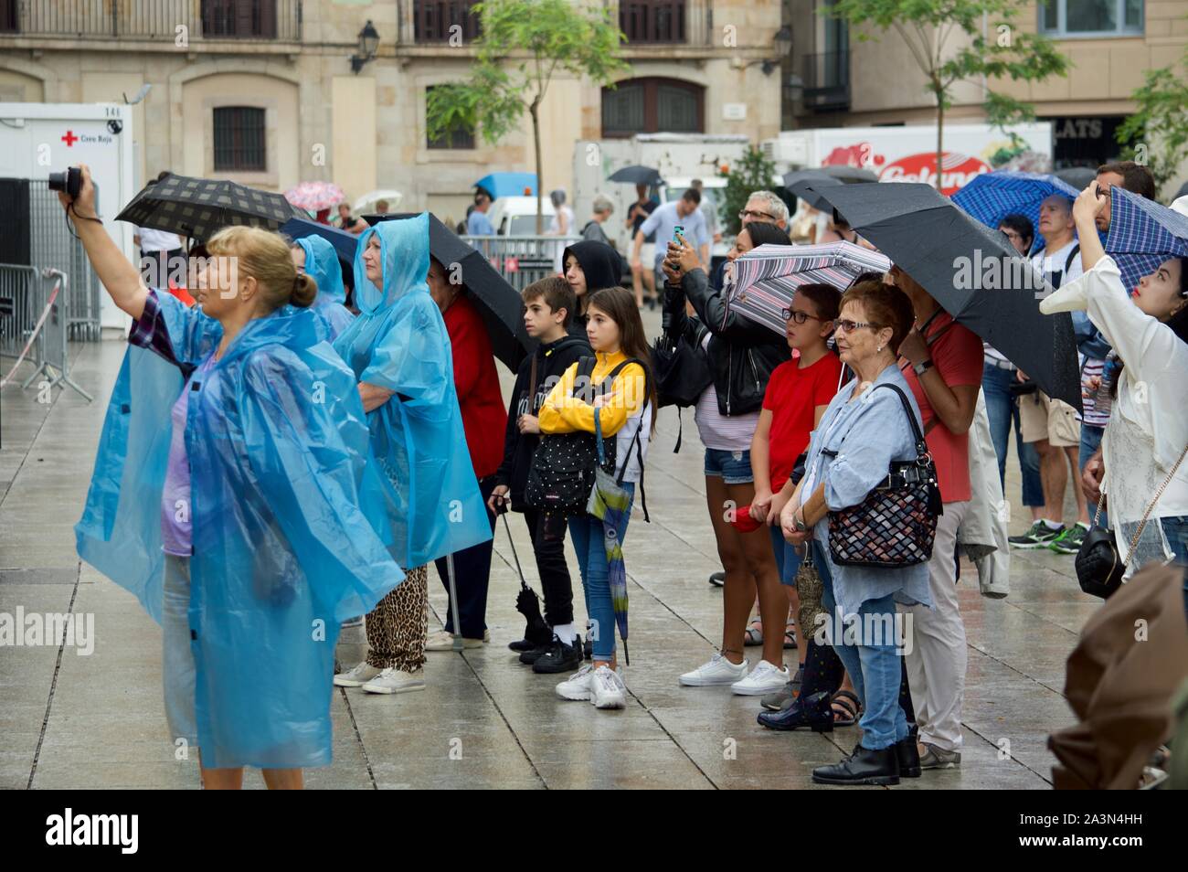 Spectators watching a performance in the rain at La Merce Festival in Barcelona, Spain Stock Photo