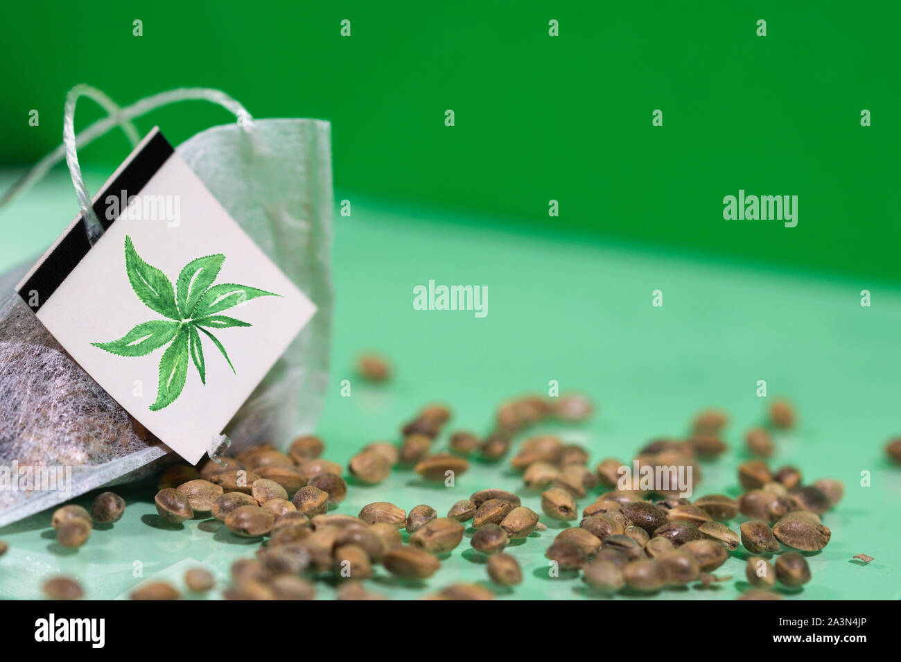 Cannabis tea bag with hemp seeds on green background, hemp tea concept