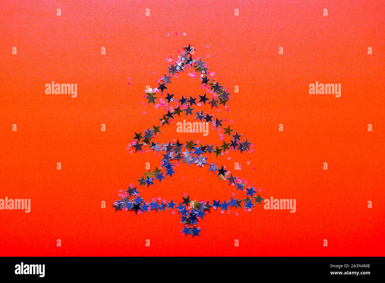 Christmas Tree made from stars on bright red background Stock Photo - Alamy