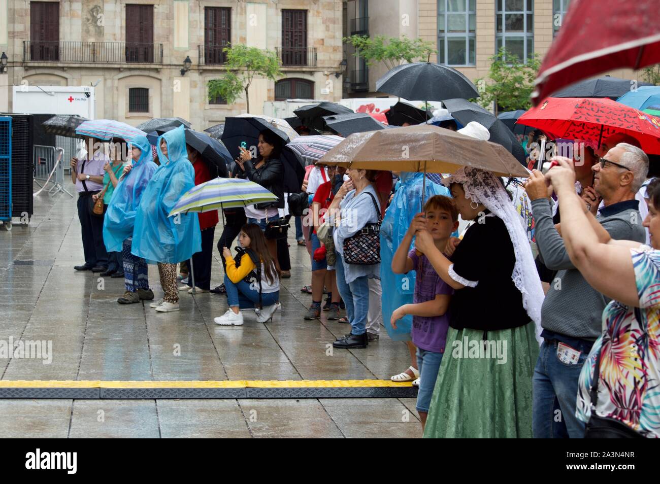 Spectators watching a performance in the rain at La Merce Festival in Barcelona, Spain Stock Photo