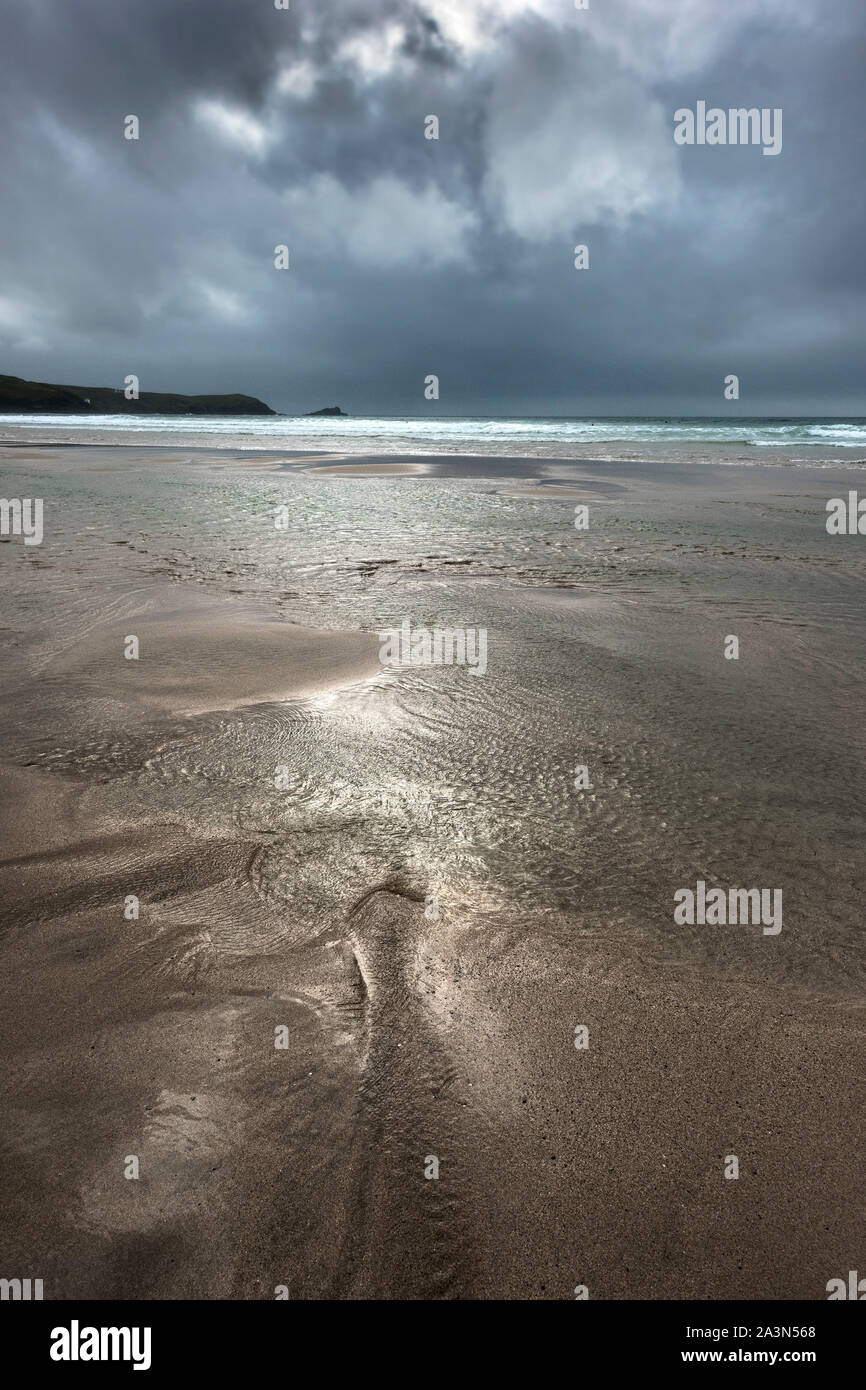 Dark rainclouds gathering over a deserted Fistral Beach in Newquay in Cornwall. Stock Photo