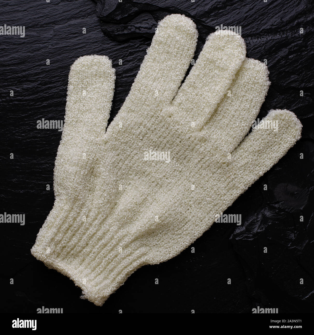 Hand bath sponge glove on black. Square image, top view Stock Photo Alamy