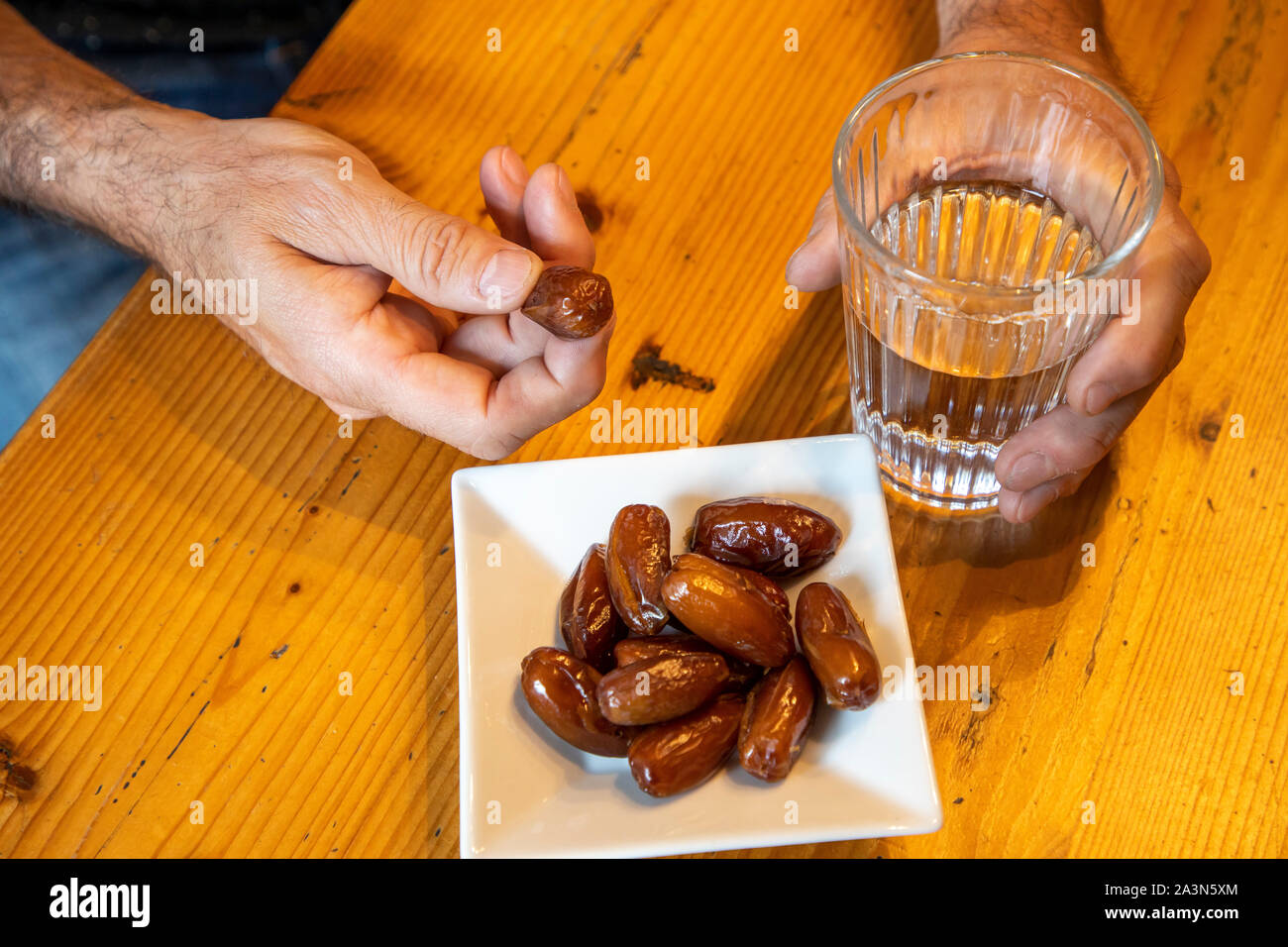 Symbol picture breaking the fast in the month of Ramadan, for Muslims, water and dates after sunset, as the first meal of the day, Stock Photo