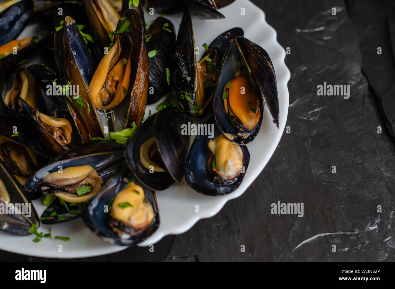 Mediterranean paleo diet food concept. Steamed mussels on dark background. Selective focus Stock Photo
