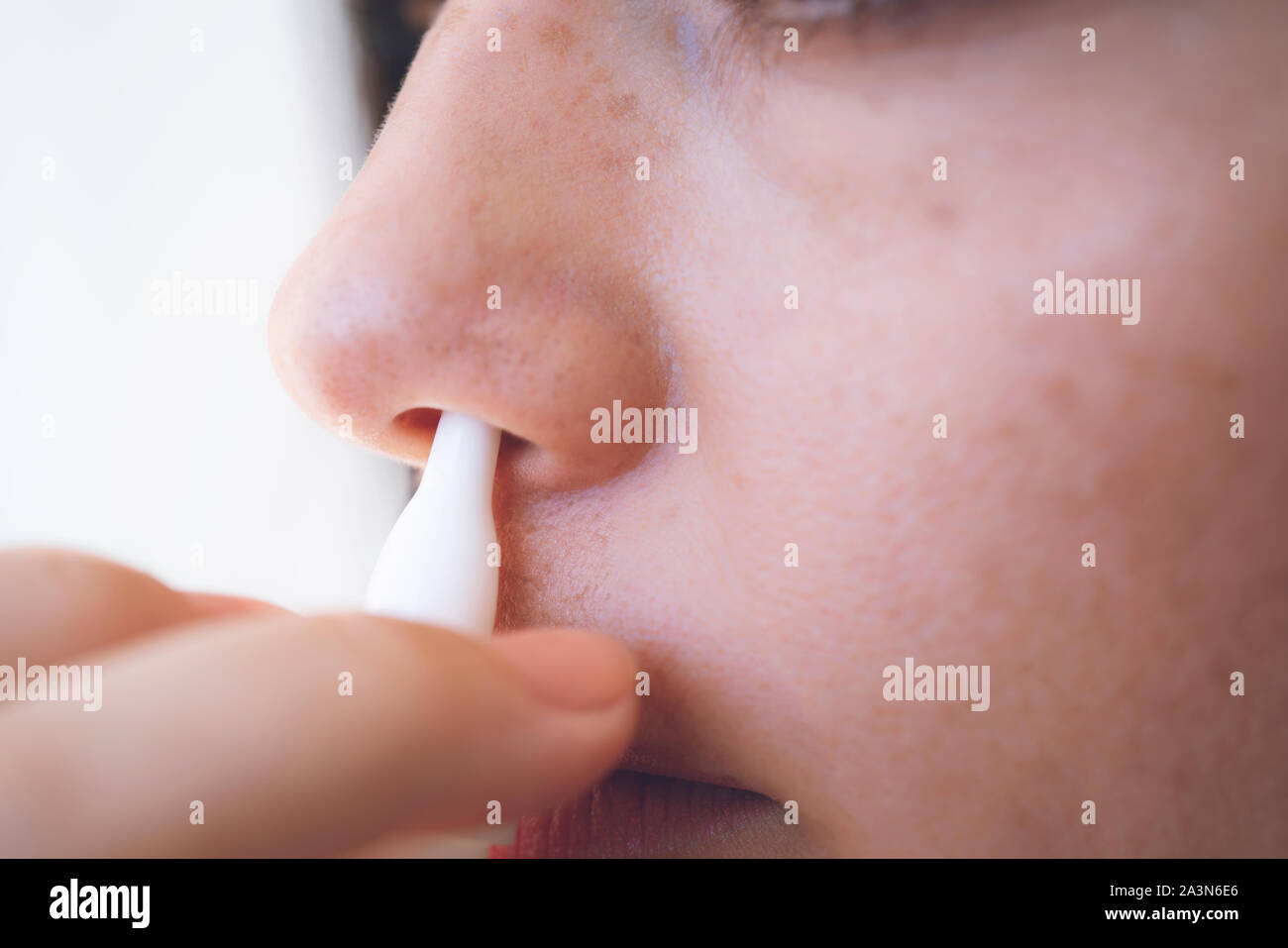 Nasal Spray. Closeup Of Beautiful Young Woman's Face With Nasal Drops. Close-up Of Female Spraying Medical Nasal Spray In Her Nose. Cold And Flu, Heal Stock Photo