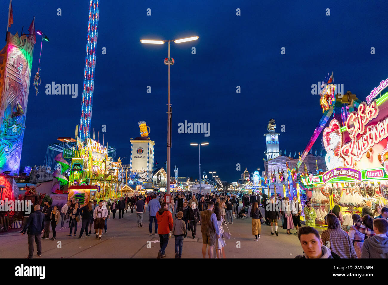 Munich, Germany - September 24: visitors, beertents and fairground rides on the oktoberfest in munich at night. Stock Photo