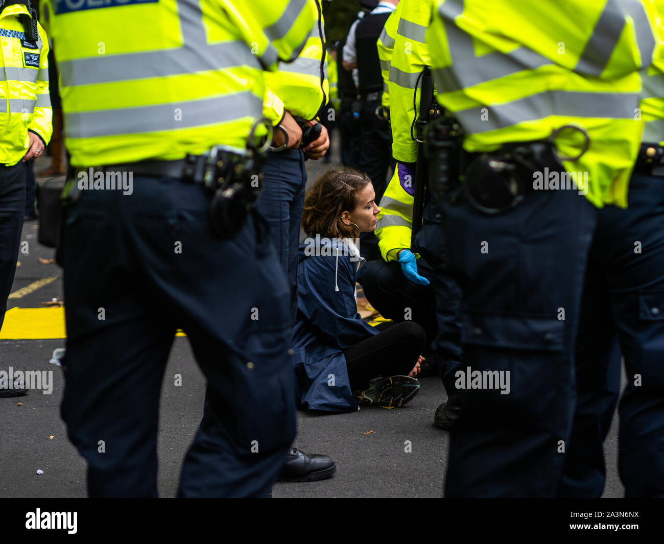 A young demonstrator was surrounded by policemen when they moved the line. One of the policemen was trying to convince her to move. Stock Photo