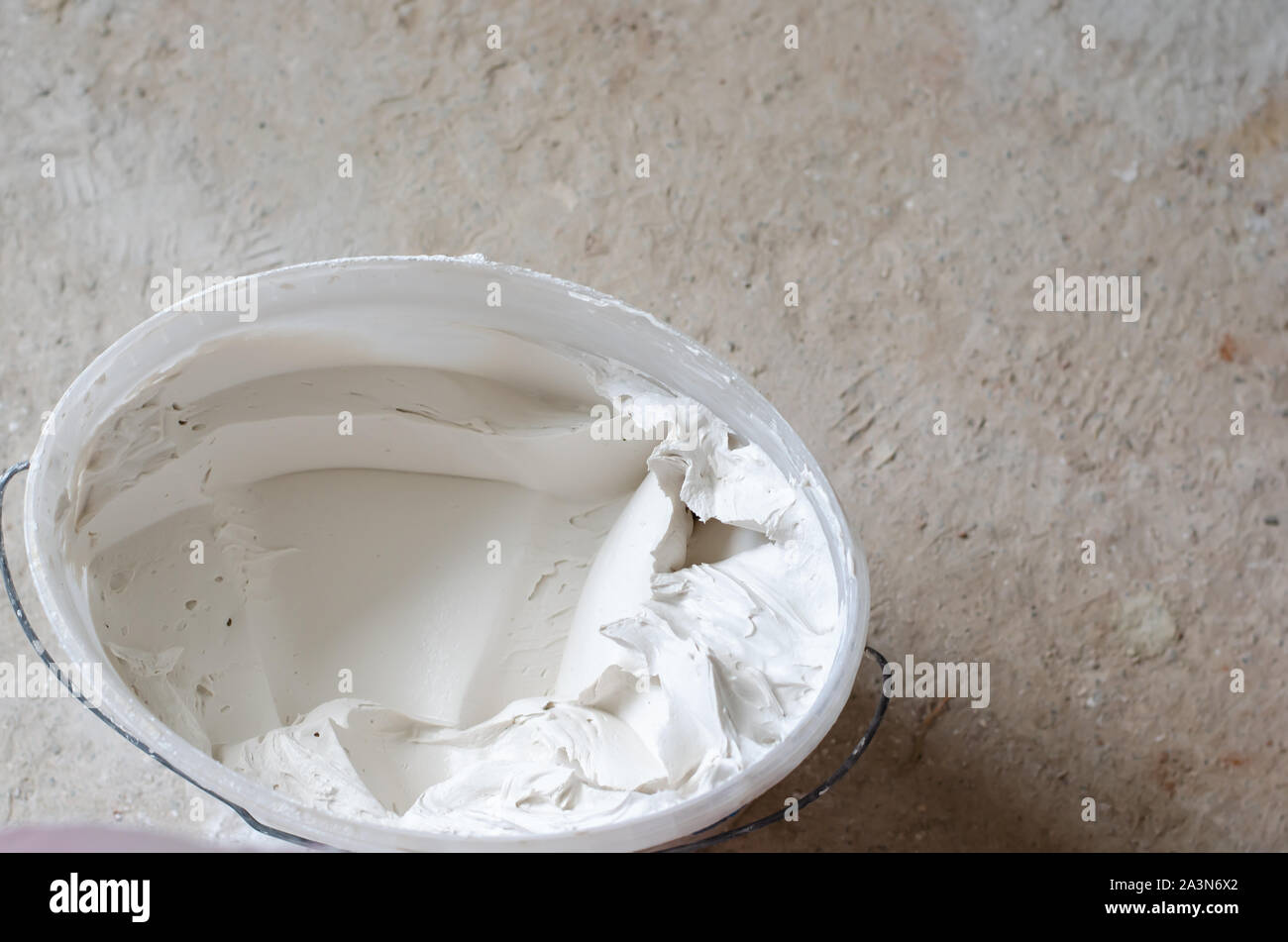 Mixed putty solution in a pail ready to be used. Construction works concept. Copy space Stock Photo