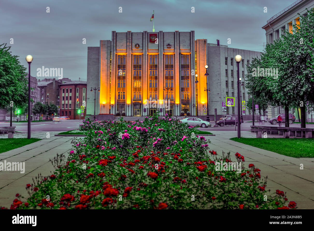 A government building illuminated at night and flowers in a park in St. Petersburg, Russia. Stock Photo