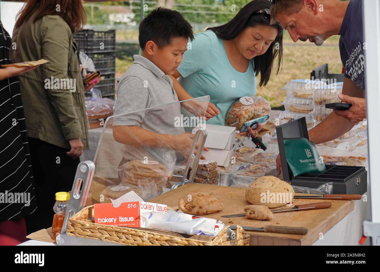 Chantilly, VA / USA - September 19, 2019: Asian family buying bread at the Chantilly Community Foodworks Farmers Market Stock Photo