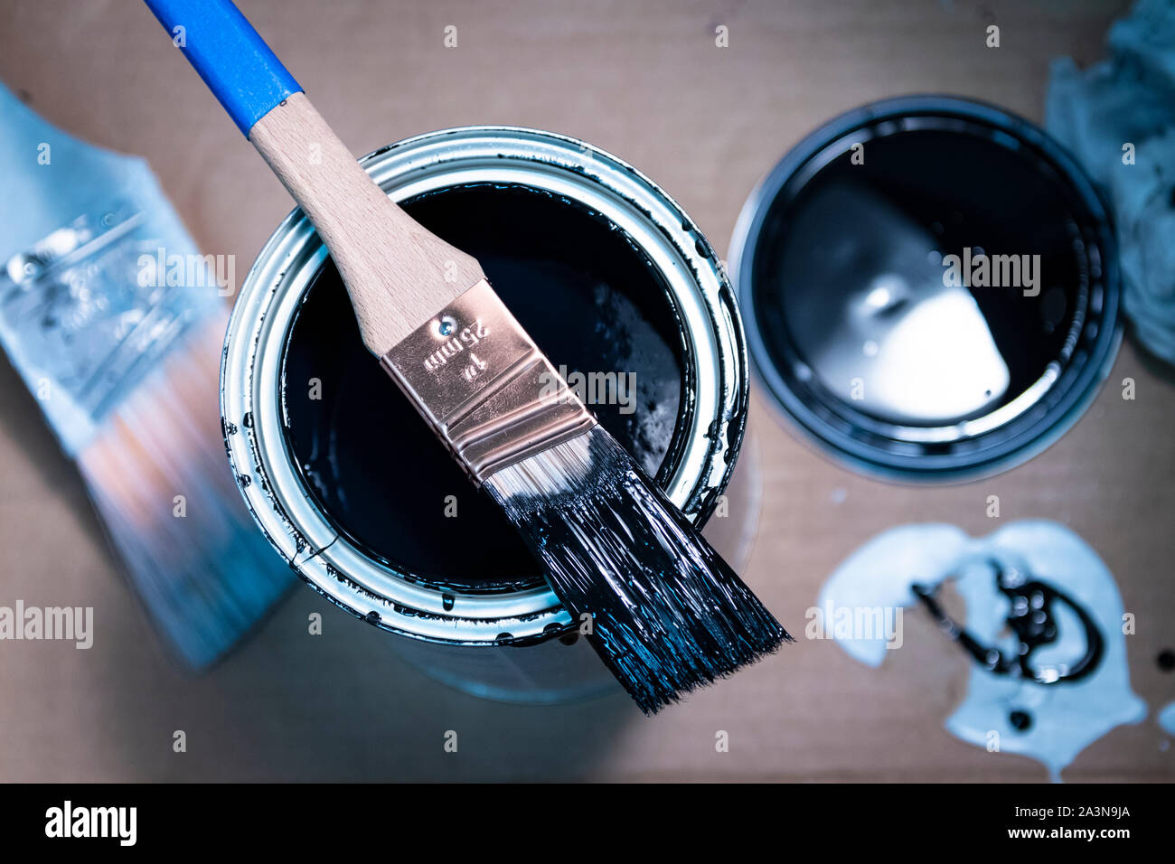 1 inch paintbrush resting on open can of enamel paint Stock Photo