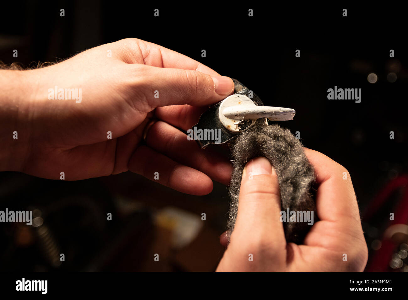 Closeup view of paint removal from metal window hardware, using steel