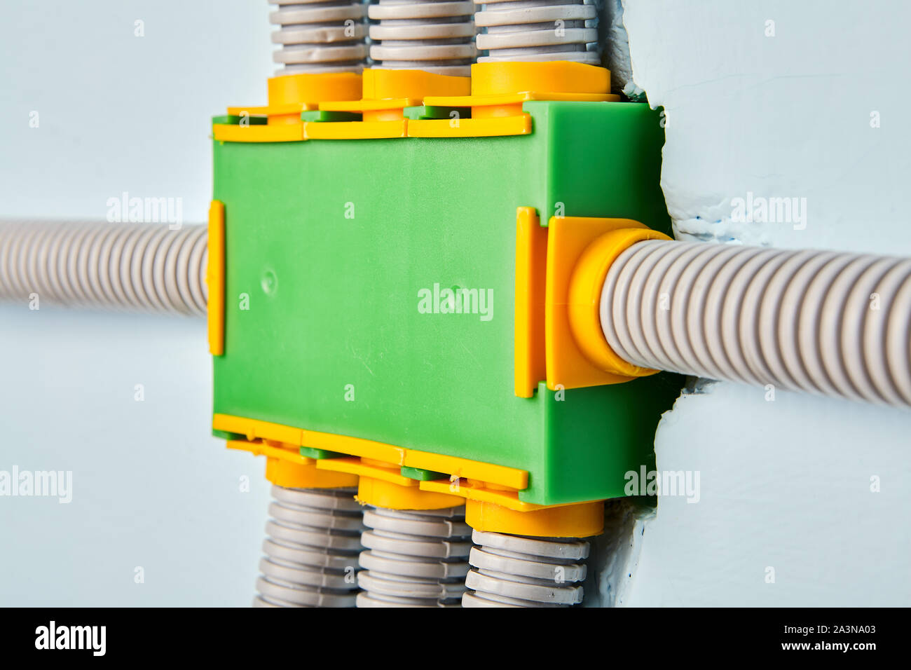 A flexible plastic electrical conduit is connected to the power distribution box of the home wiring system. Electric equipment is mounted on the insid Stock Photo