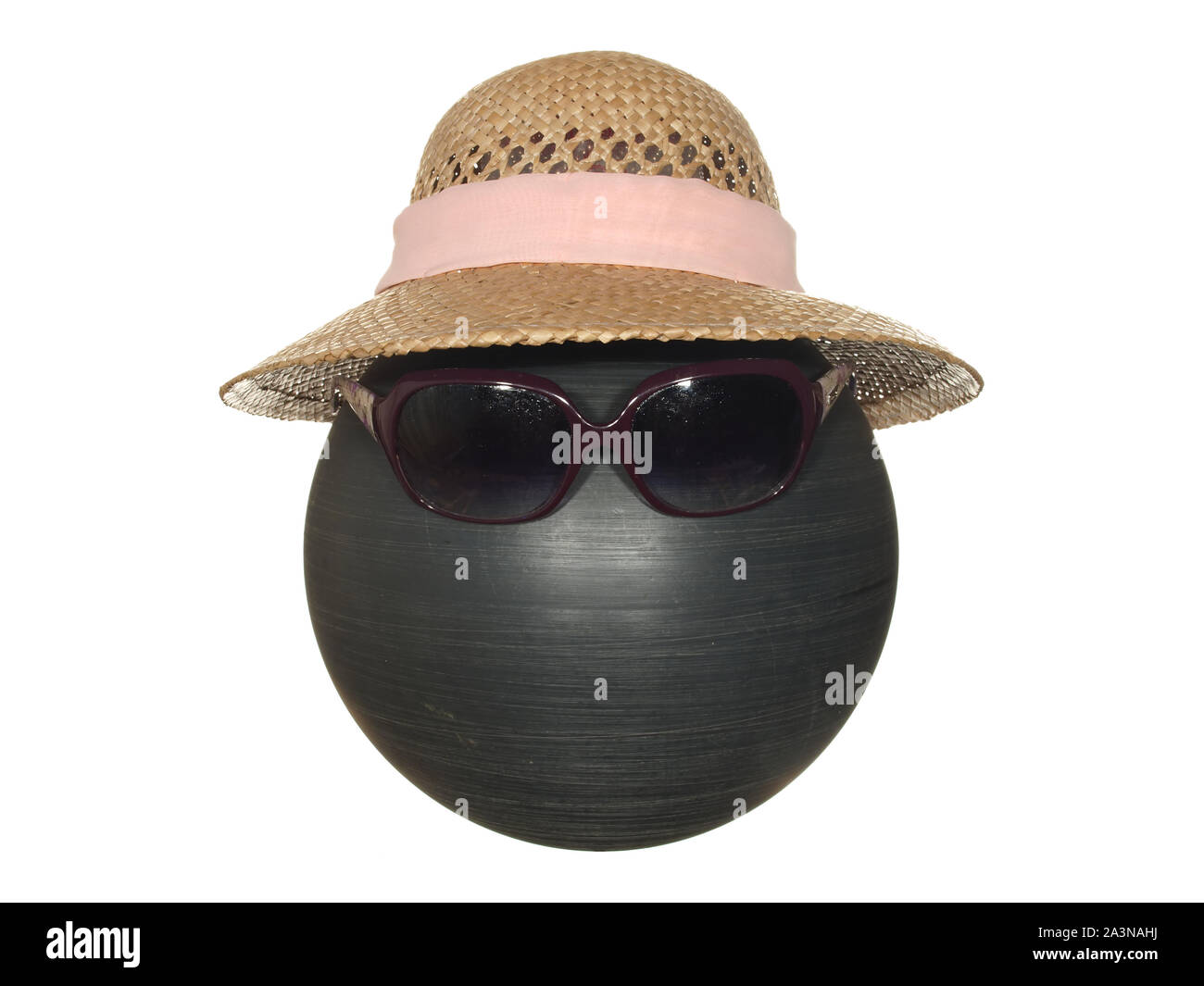 Lady's straw hat with pink ribbon and dark safety glasses on a black plastic ball isolated on a white background. Stock Photo