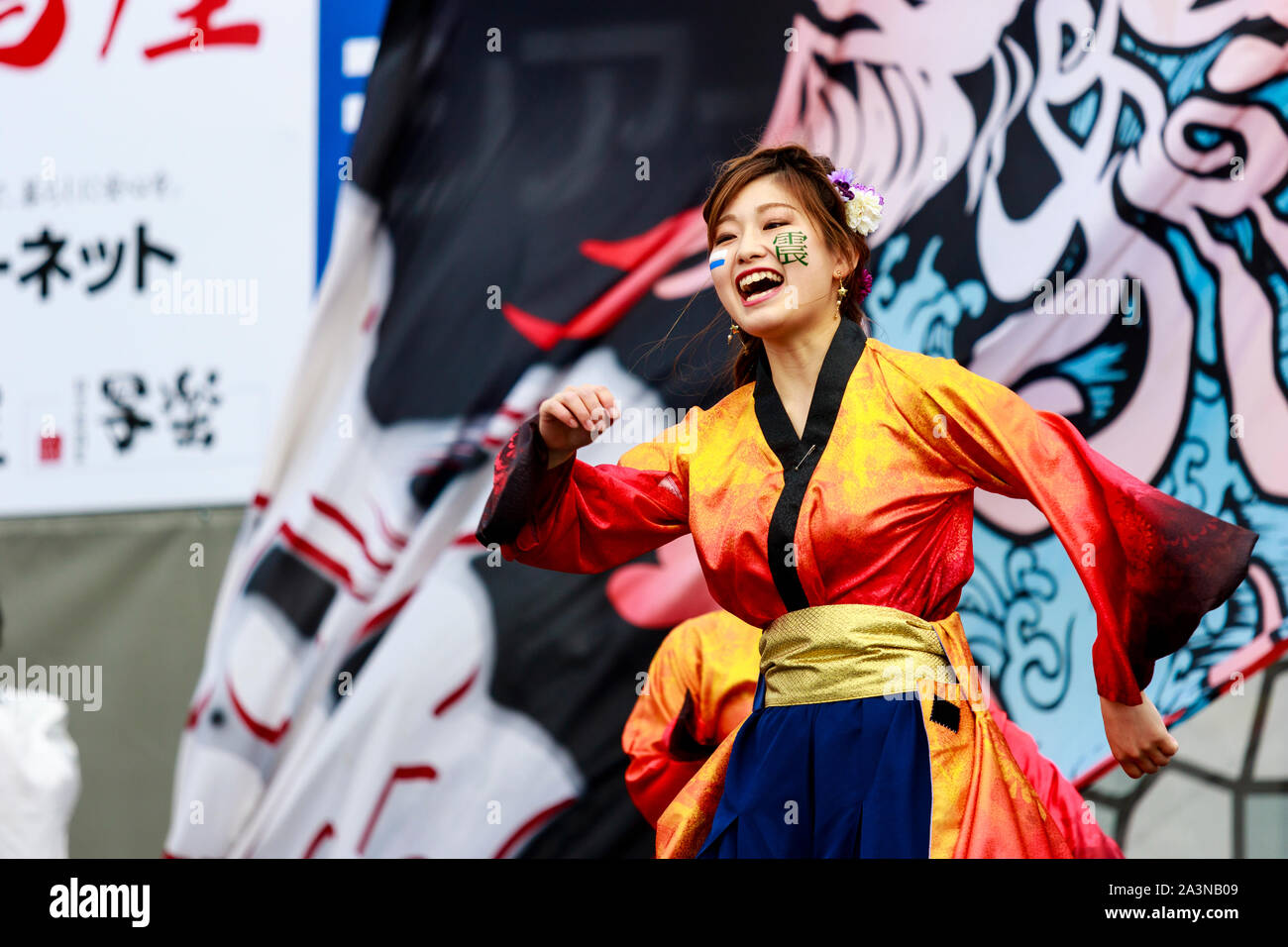 Kyusyu Gassai festival in Kumamoto, Japan. Close up of Yosakoi dancer dancing, with mouth wide open and happy expression. Wears red and yellow jacket. Stock Photo