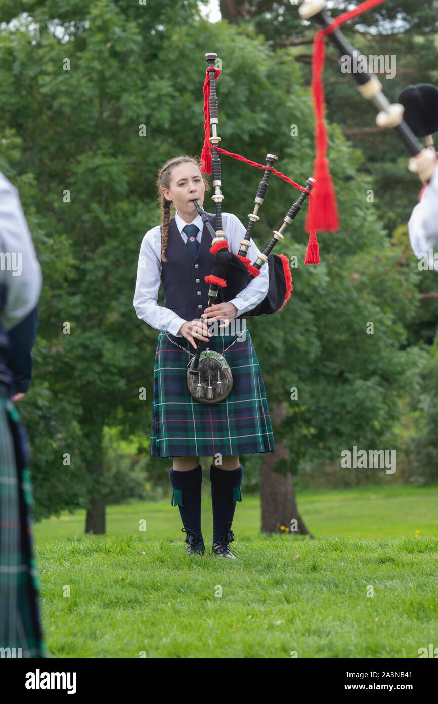 Girl from the Camelon and District Pipe Band playing the bagpipes at the Peebles highland games. Scottish borders, Scotland Stock Photo