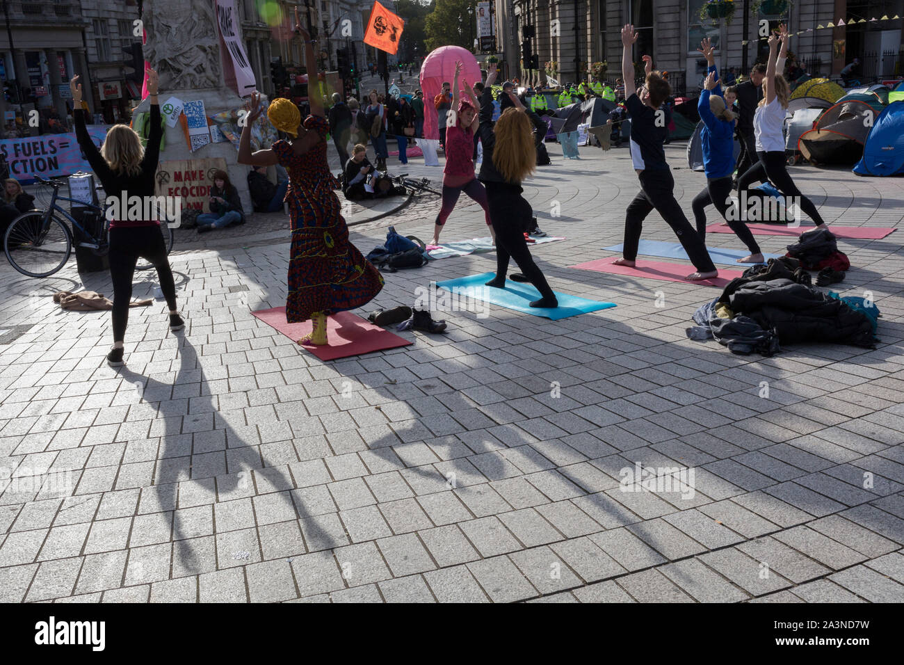 Environmental activists practice yoga while protesting about Climate Change during an occupation of Trafalgar Square in central London, the third day of a two-week prolonged worldwide protest by members of Extinction Rebellion, on 9th October 2019, in London, England. Stock Photo