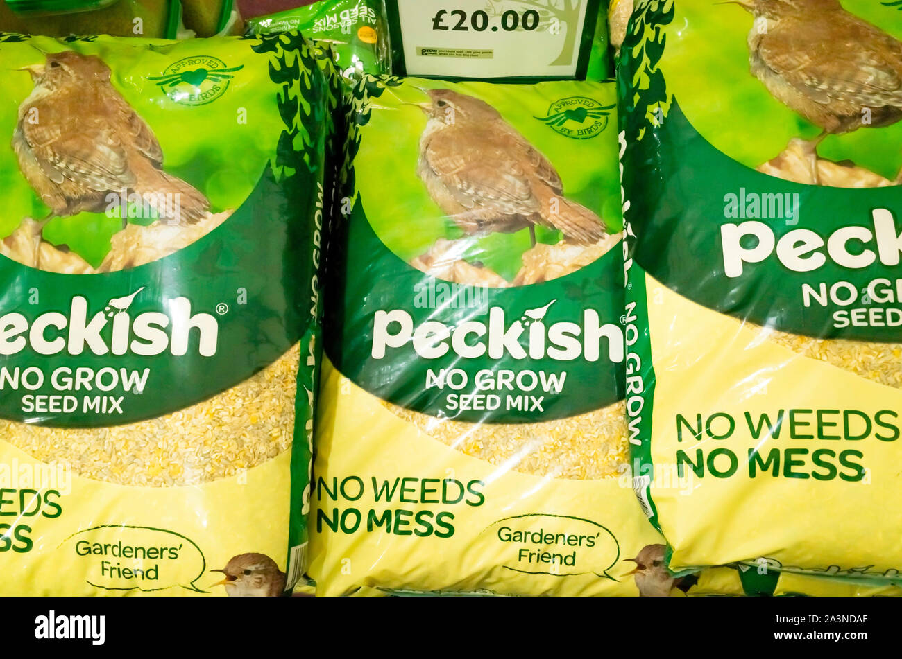 A stack of large bags of Peckish brand wild bird food for sale in a garden centre in North Yorkshire England Stock Photo