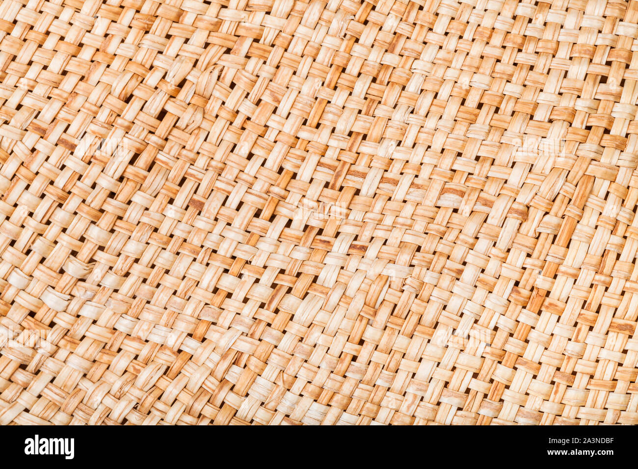 textile background - weaving of summer straw hat from natural raffia fibers close up Stock Photo