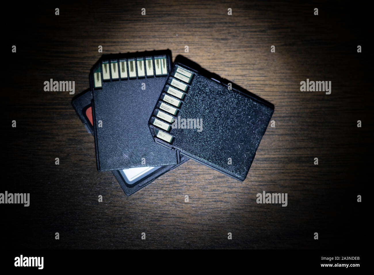 SD data cards on desktop, under round light as if discovered under flashlight investigation. Stock Photo