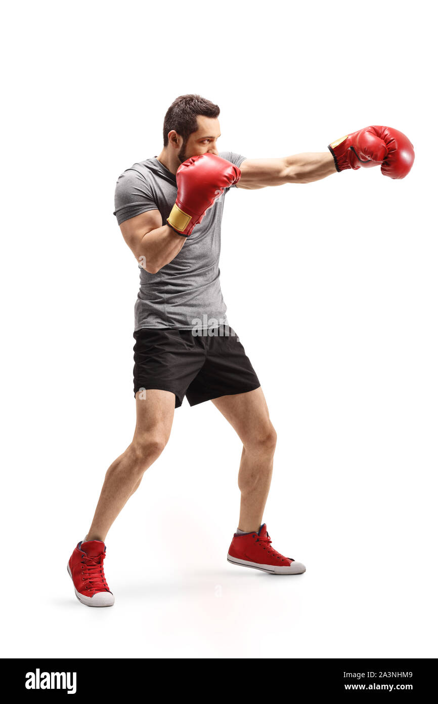 Full length shot of a strong young man punching with boxing gloves
