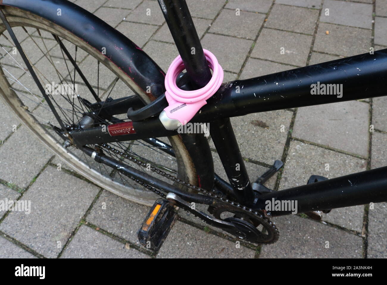 Pink bicycle lock on black bicycle Stock Photo