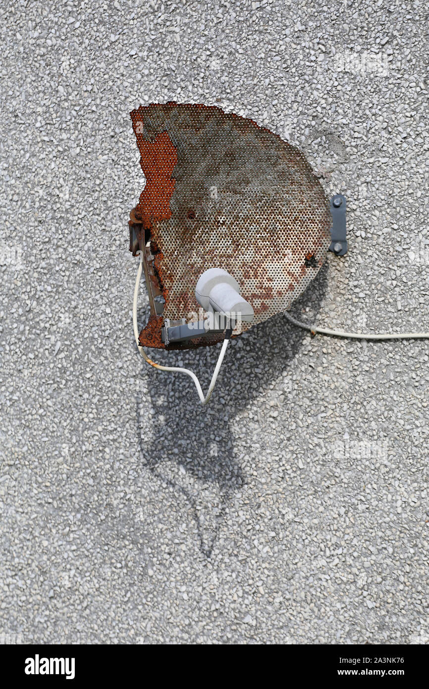 A weather beaten satelite dish used to receive SKY TV. Stock Photo