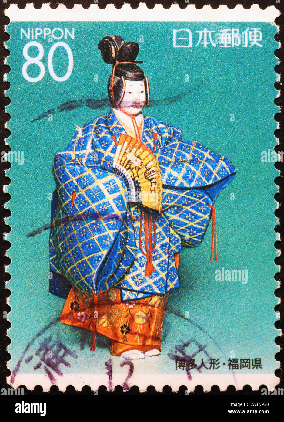 Doll reproducing a geisha on japanese postage stamp Stock Photo